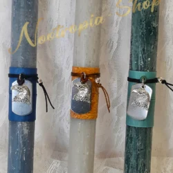 Χειροποίητη πασχαλινή λαμπάδα σε τρεις μοναδικές αποχρώσεις (μπλε denim, γκρι πέτρας, κυπαρισσί), διακοσμημένη με ανάγλυφο μεταλλικό στοιχείο κεφάλι αετού σε vintage στυλ. Μια επιλογή με δυναμισμό και χαρακτήρα, ιδανική για εφήβους και άνδρες.